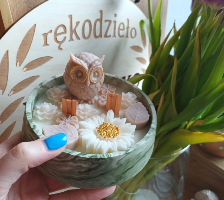 swieca w okraglym gipsie w kolorze zielonym marmurkowym z sowa oraz kwiatami w odcieniach bieli i bezu