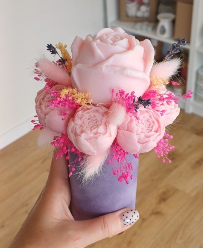 Pachnący flower box z wosku sojowego z różowymi różami i suszkami w fioletowym welurowym pudełku.