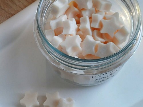 wosk sojowy w kształcie gwiazdek koloru beżowego w przezroczystym słoiku